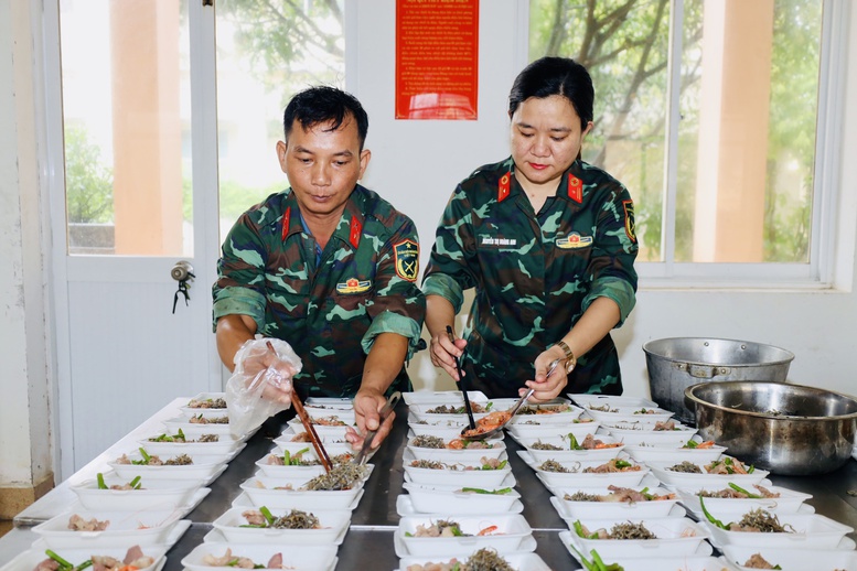 Bộ đội chuẩn bị c&aacute;c phần cơm để đưa đến v&ugrave;ng ngập s&acirc;u, chia cắt hỗ trợ người d&acirc;n.