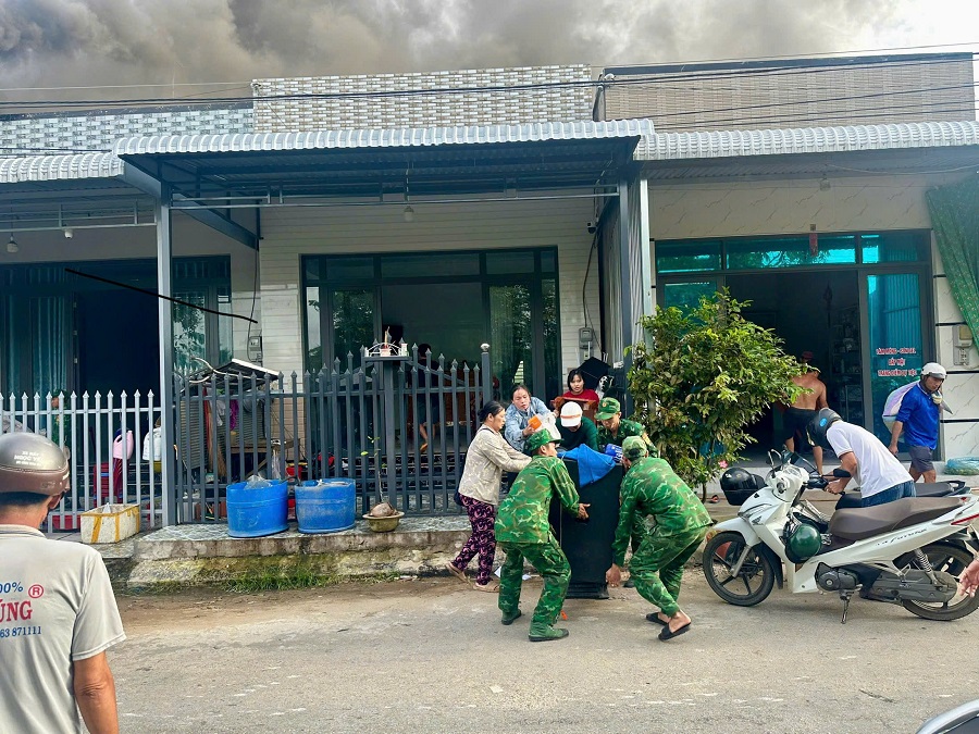 Cán bộ, chiến sĩ Đồn Biên phòng cửa khẩu quốc tế Vĩnh Xương hỗ trợ người dân di chuyển tài sản ra khu vực an toàn.