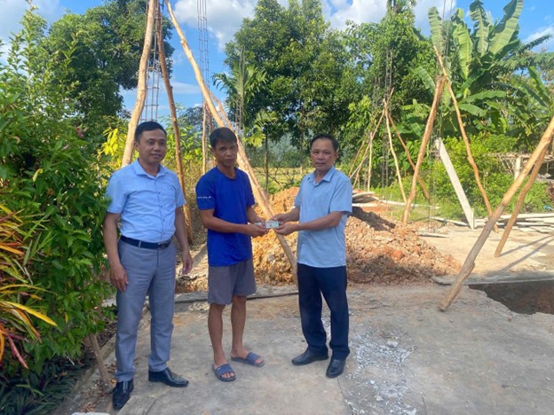 Đại diện chính quyền xã Hưng Khánh trao tiền hỗ trợ xây nhà. Ảnh: Chính quyền địa phương cung cấp