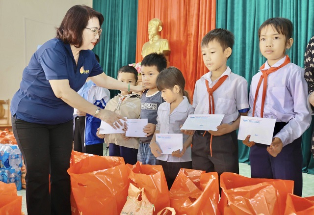 Bà Đồng Thị Ánh (bìa trái) trao quà cho các cháu học sinh. Ảnh: Lâm Vy.