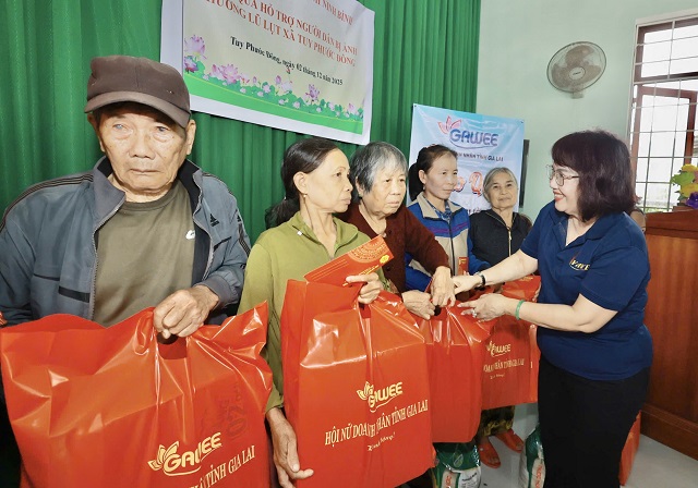 Bà Đồng Thị Ánh (bìa phải) trao quà hỗ trợ đồng bào xã Tuy Phước Đông. Ảnh: Lâm Vy.