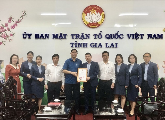 Ông Trần Minh Sơn (thứ 5 từ trái qua) trao Thư cảm ơn của Uỷ ban MTTQ Việt Nam tỉnh Gia Lai cho đại diện Ngân hàng MB. Ảnh: Viết Hiền