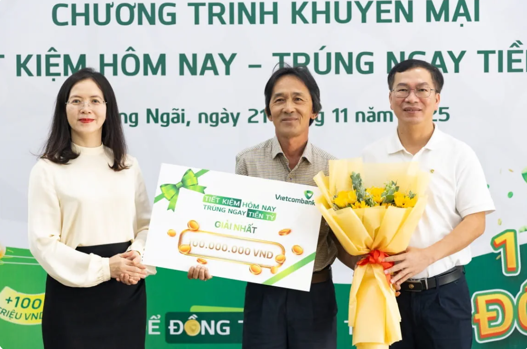 Anh Võ Tấn Điệp (đứng giữa) nhận Giải Nhất trị giá 100 triệu đồng trong chương trình “Tiết kiệm hôm nay - Trúng ngay tiền tỷ” tại Vietcombank Quảng Ngãi