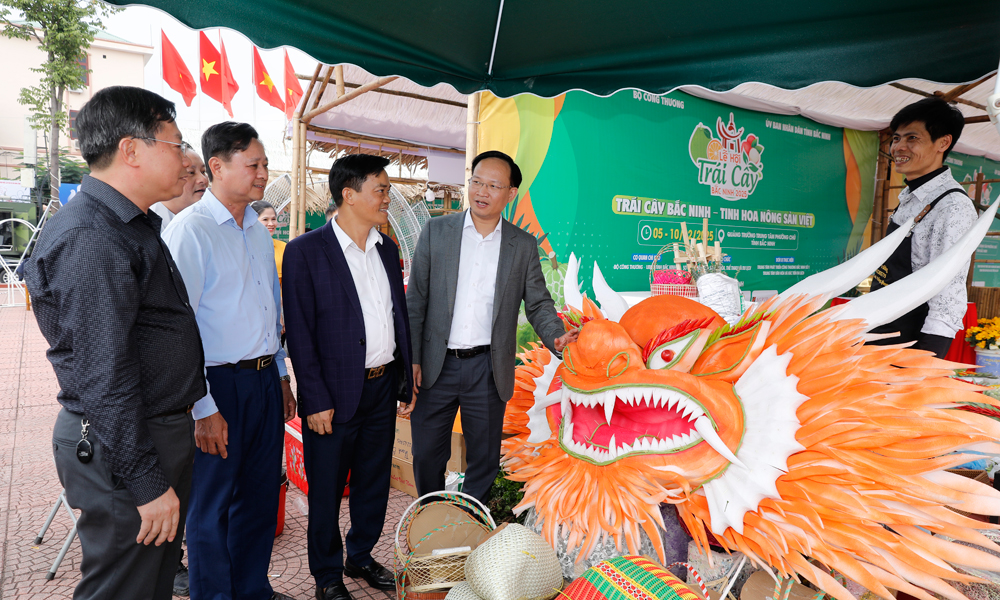 Đồng chí Phạm Văn Thịnh và thành viên Ban Tổ chức kiểm tra tiến độ thi công tại gian trưng bày trái cây và sản phẩm OCOP của phường Chũ.