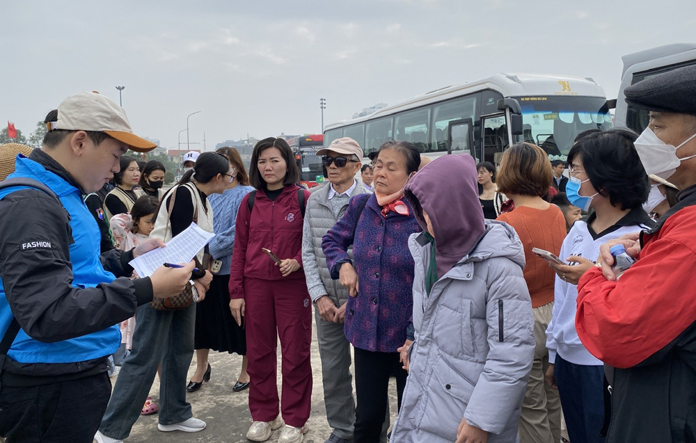 Đại diện Ban Tổ chức đọc danh sách người đăng ký đi xe miễn phí tại điểm đón ở Quảng trường 3/2 (phường Bắc Giang).