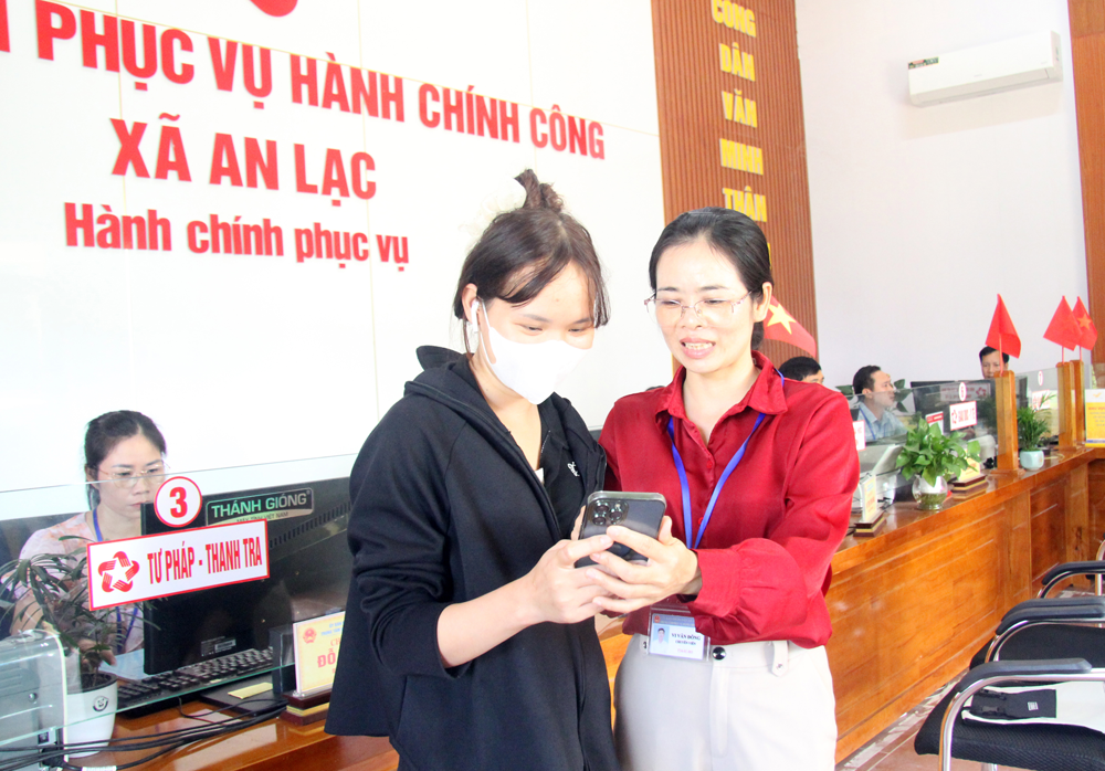 Công chức Trung tâm Phục vụ hành chính công xã An Lạc hướng dẫn người dân nộp hồ sơ trực tuyến.