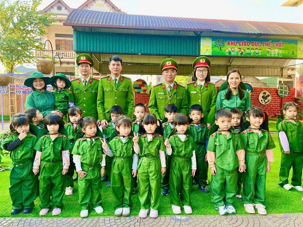 C&aacute;c c&aacute;n bộ, chiến sĩ C&ocirc;ng an x&atilde; Hợp Tiến chụp ảnh lưu niệm c&ugrave;ng c&aacute;c c&ocirc; gi&aacute;o v&agrave; c&aacute;c em học sinh trường Mầm non Nam Hưng.