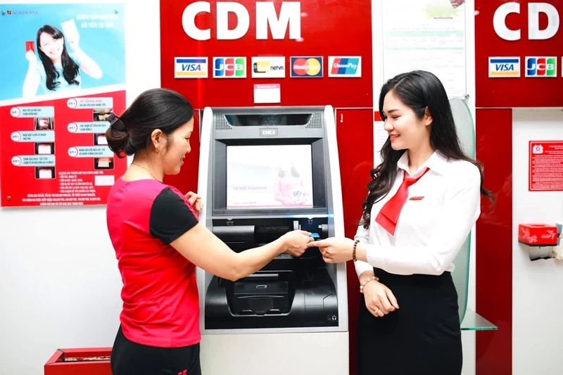 C&aacute;n bộ Agribank Thanh H&oacute;a hướng dẫn kh&aacute;ch h&agrave;ng thực hiện c&aacute;c giao dịch điện tử qua m&aacute;y CDM tại đường Phan Chu Trinh (TP Thanh H&oacute;a).