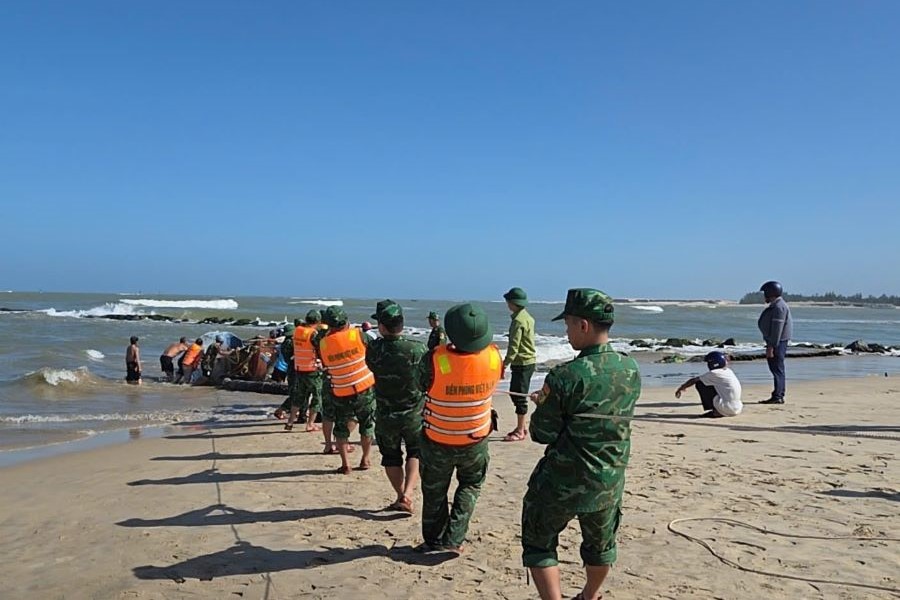 C&aacute;n bộ chiến sĩ Đồn Bi&ecirc;n ph&ograve;ng cửa khẩu cảng Cửa Việt c&ugrave;ng c&aacute;c lực lượng, người d&acirc;n k&eacute;o ghe bị ch&igrave;m l&ecirc;n bờ.