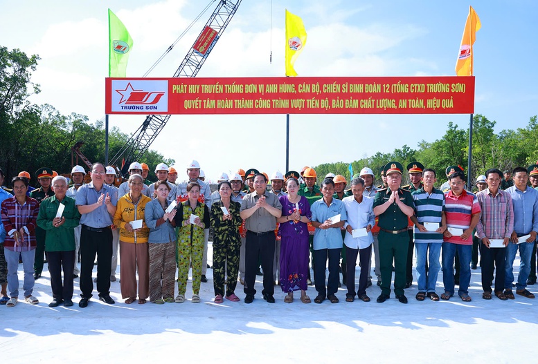 Thủ tướng Phạm Minh Ch&iacute;nh tặng qu&agrave; người d&acirc;n tại điểm đầu x&acirc;y dựng tuyến giao th&ocirc;ng ra đảo H&ograve;n Khoai - Ảnh: TTXVN