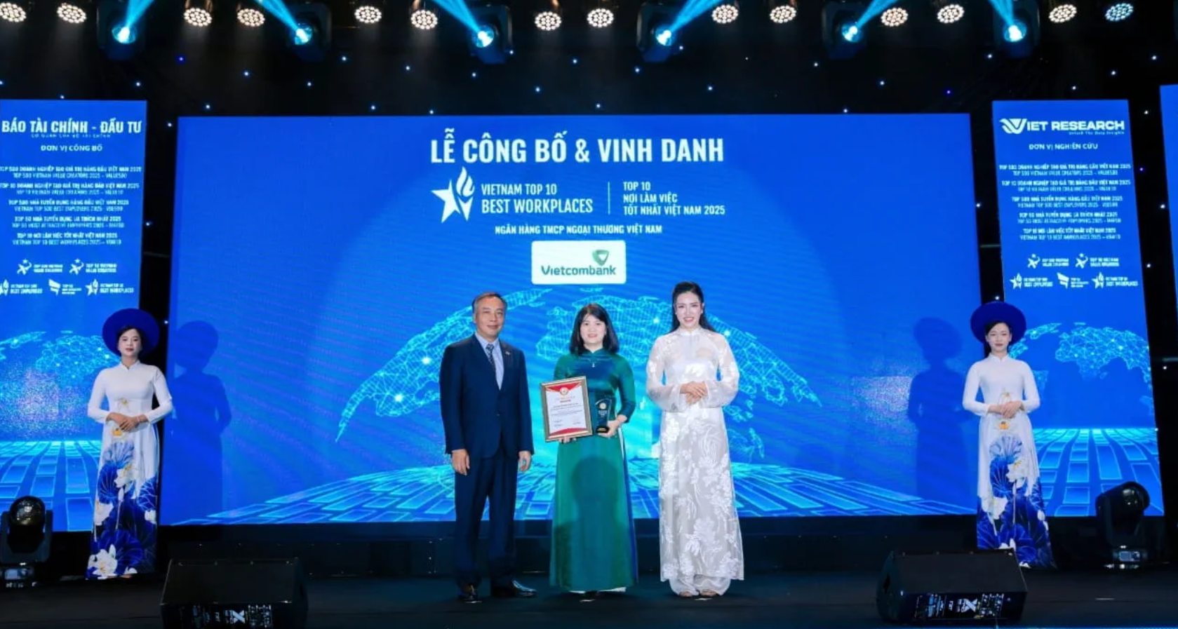 Đại diện Vietcombank, b&agrave; Nguyễn Ho&agrave;ng H&agrave; - Ph&oacute; Trưởng ph&ograve;ng Ch&iacute;nh s&aacute;ch v&agrave; Kế hoạch nh&acirc;n sự (đứng giữa) nhận giải thưởng &ldquo;Top 10 Nơi l&agrave;m việc tốt nhất Việt Nam ng&agrave;nh Ng&acirc;n h&agrave;ng năm 2025&rdquo; (Vietcombank xếp thứ 1). Ảnh: VCB