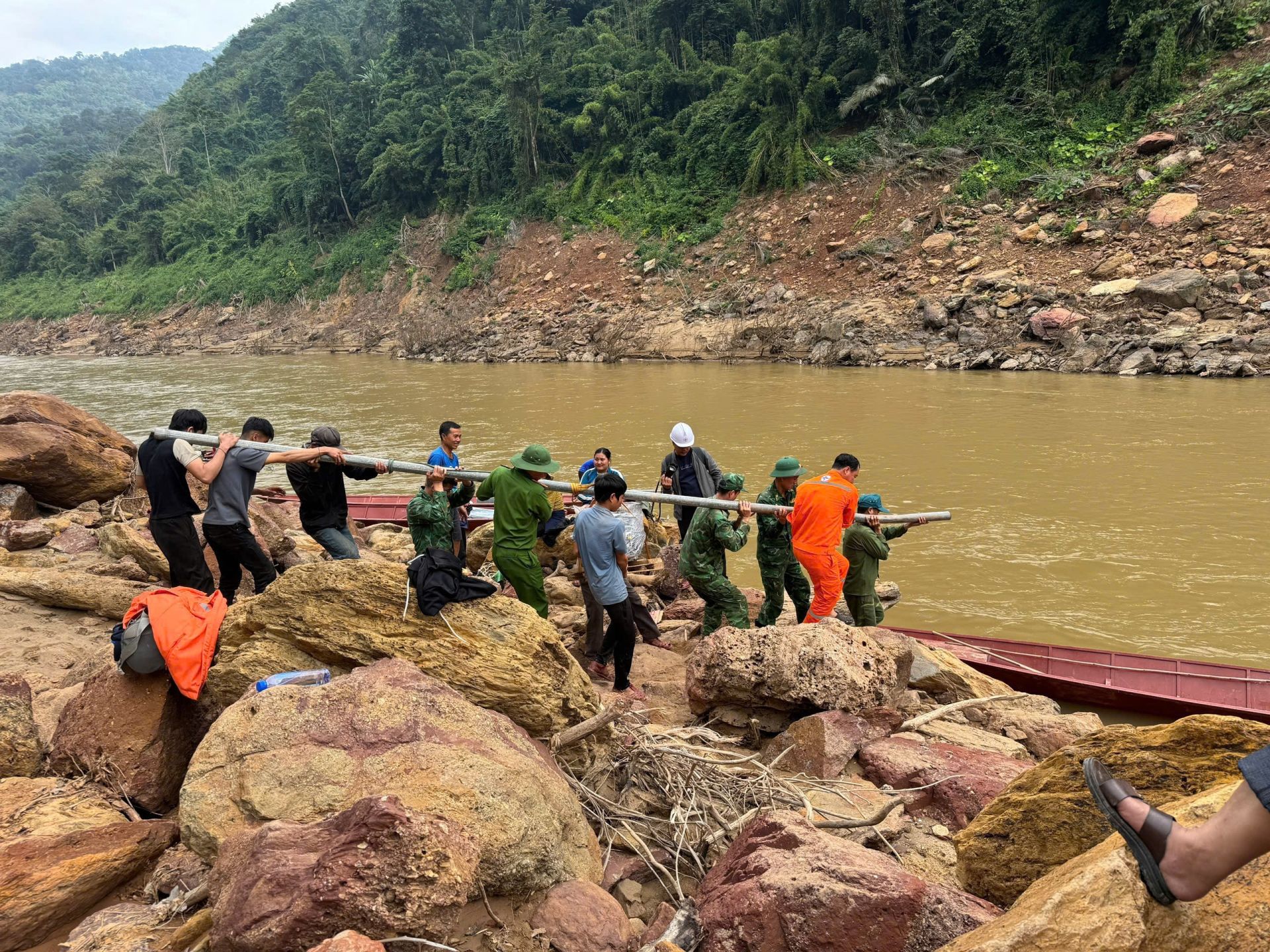 C&aacute;n bộ, c&ocirc;ng nh&acirc;n EVNNPC phối hợp c&ugrave;ng lực lượng địa phương vận chuyển cột, vật tư vượt s&ocirc;ng, đưa điện về c&aacute;c th&ocirc;n, bản v&ugrave;ng s&acirc;u, v&ugrave;ng xa