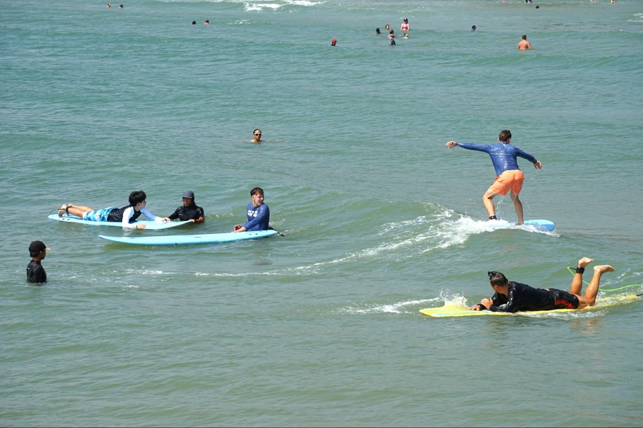 Du kh&aacute;ch th&iacute;ch th&uacute; với tr&ograve; chơi lướt s&oacute;ng. Ảnh PV