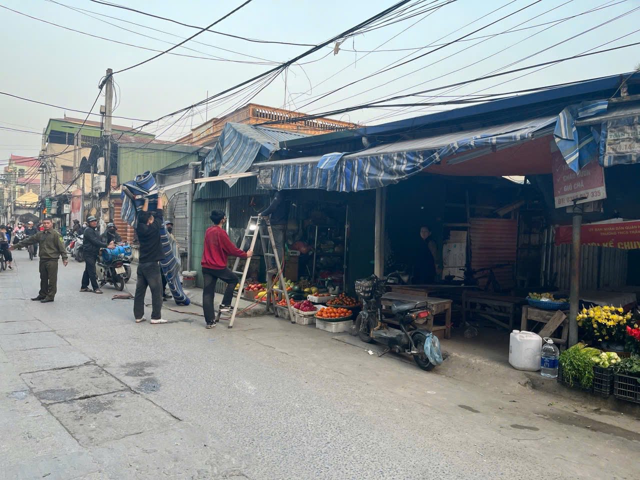 Lực lượng chức năng và người dân thu dọn mái che, hàng hóa tại khu vực chợ cóc, chợ tạm trên địa bàn phường Lĩnh Nam trong buổi ra quân giải tỏa. Lực lượng chức năng và người dân thu dọn mái che, hàng hóa tại khu vực chợ cóc, chợ tạm trên địa bàn phường Lĩnh Nam trong buổi ra quân giải tỏa.