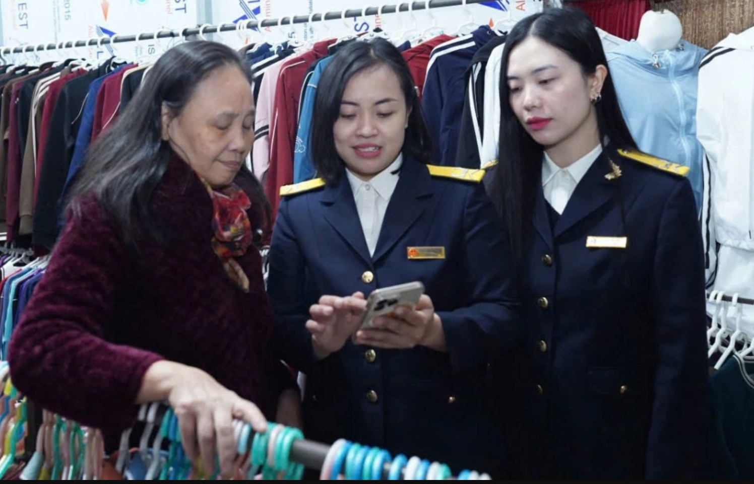 Công chức Thuế TP. Hà Nội hướng dẫn hộ kinh doanh làm thủ tục nộp thuế. Ảnh: KT Công chức Thuế TP. Hà Nội hướng dẫn hộ kinh doanh làm thủ tục nộp thuế. Ảnh: KT