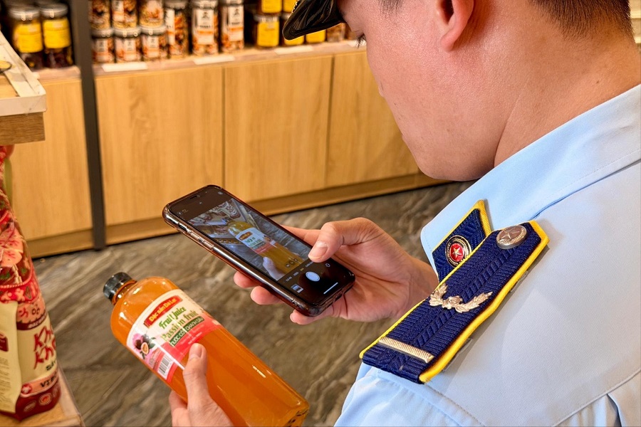 Lực lượng chức năng kiểm tra nguồn gốc xuất xứ h&agrave;ng h&oacute;a bằng m&atilde; QR