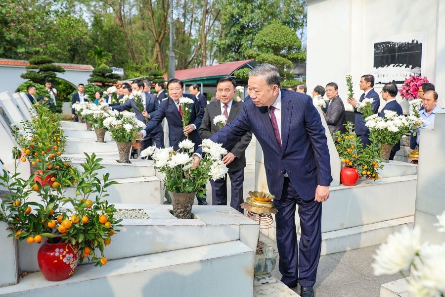 Tổng B&iacute; thư T&ocirc; L&acirc;m v&agrave; c&aacute;c đồng ch&iacute; trong đo&agrave;n d&acirc;ng hoa l&ecirc;n phần mộ c&aacute;c nữ liệt sỹ TNXP