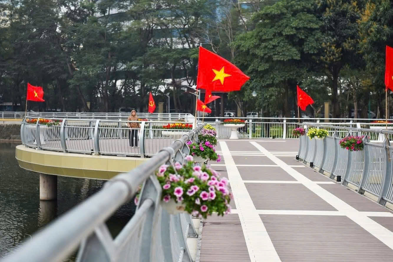 Hệ thống đường dạo ven hồ trong C&ocirc;ng vi&ecirc;n Nghĩa Đ&ocirc; sau cải tạo trở n&ecirc;n th&ocirc;ng tho&aacute;ng, sạch đẹp, được trang tr&iacute; hoa v&agrave; cờ Tổ quốc, tạo điểm nhấn cảnh quan v&agrave; kh&ocirc;ng gian thư gi&atilde;n cho người d&acirc;n.