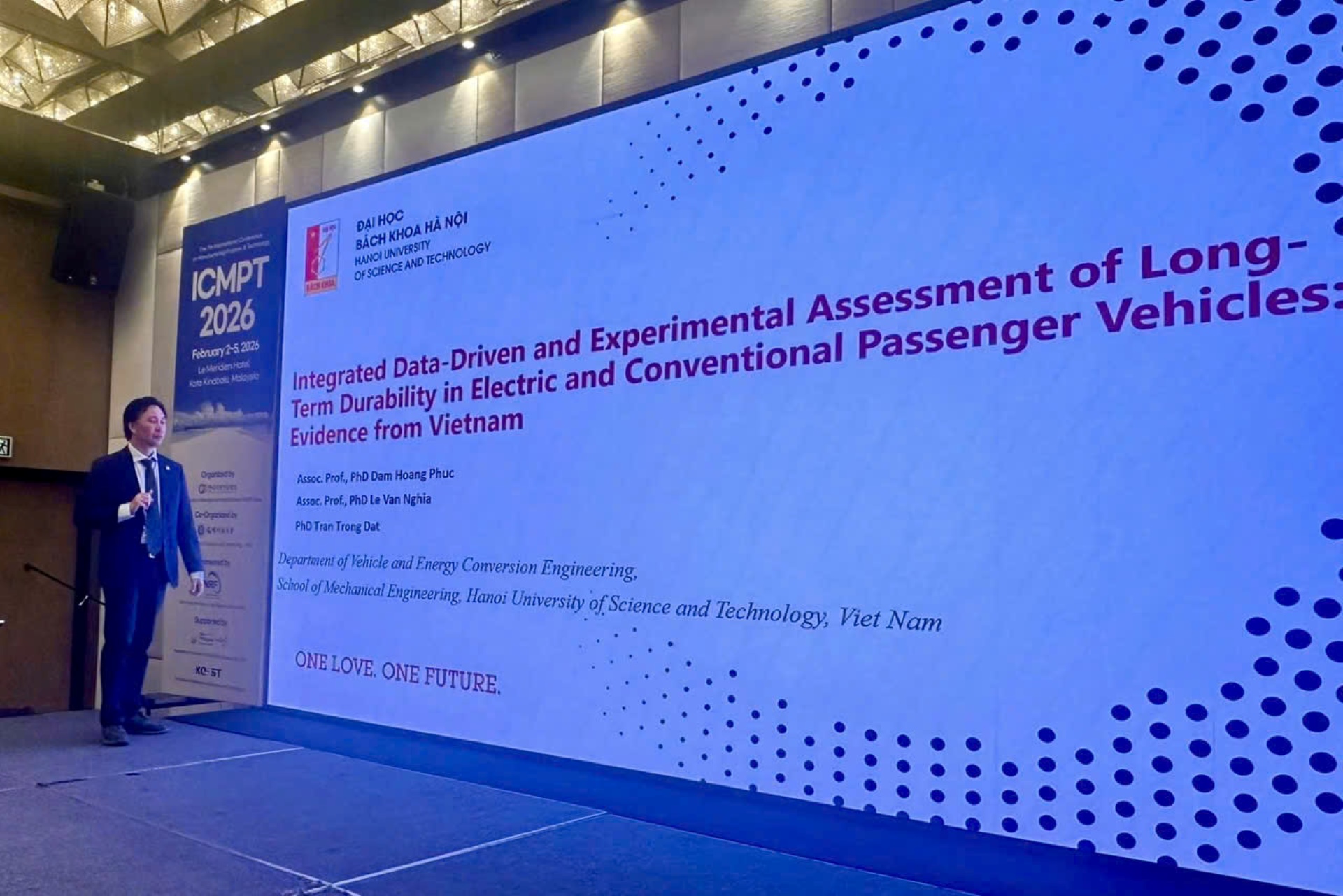 PGS. TS Đ&agrave;m Ho&agrave;ng Ph&uacute;c tr&igrave;nh b&agrave;y b&aacute;o c&aacute;o khoa học so s&aacute;nh độ bền của xe xăng v&agrave; xe điện tại hội nghị ICMPT 2026.