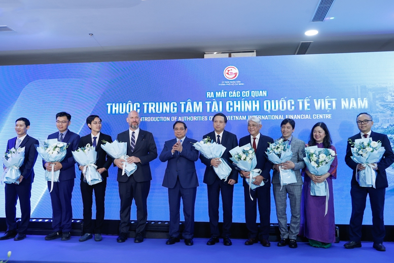 Thủ tướng Phạm Minh Ch&iacute;nh tặng hoa cho đại diện c&aacute;c cơ quan thuộc Trung t&acirc;m T&agrave;i ch&iacute;nh quốc tế Việt Nam - Ảnh: VGP/Nhật Bắc