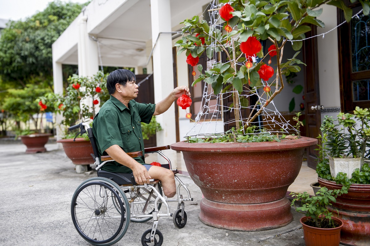 B&aacute;c Nguyễn C&ocirc;ng Thắng &ndash; cựu chiến binh đang được chăm s&oacute;c tại Trung t&acirc;m Điều dưỡng Thương binh v&agrave; Người c&oacute; c&ocirc;ng Long Đất &ndash; chăm ch&uacute;t cho g&oacute;c Tết trước ph&ograve;ng ở (Ảnh: Minh Anh).