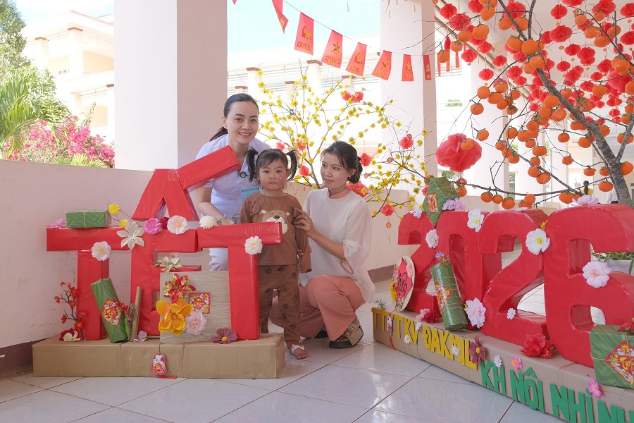 Chị Đặng Thị Thủy v&agrave; con lưu lại khoảnh khắc c&ugrave;ng nh&acirc;n vi&ecirc;n y tế b&ecirc;n tiểu cảnh Tết trong bệnh viện