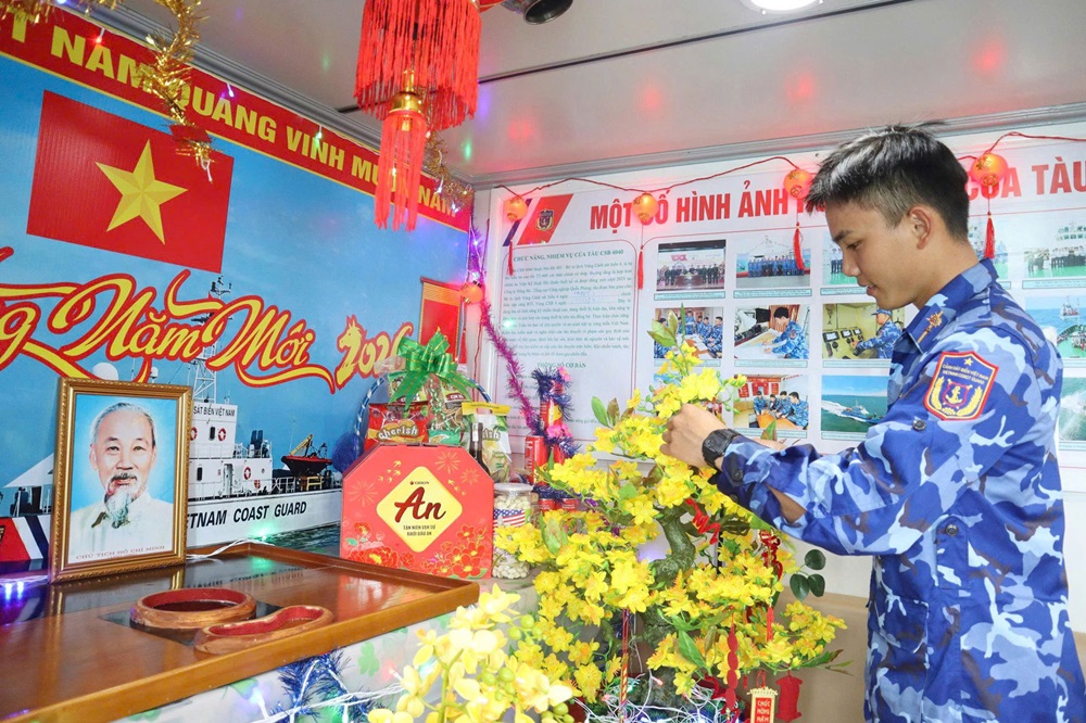 Chiến sĩ trẻ lần đầu trực Tết xa nh&agrave; n&acirc;ng niu c&agrave;nh mai nhỏ được mang từ đất liền