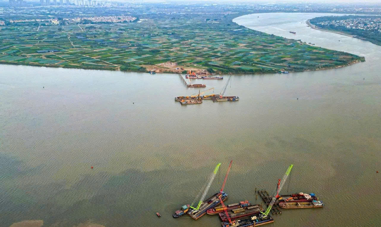 To&agrave;n cảnh c&ocirc;ng trường thi c&ocirc;ng cầu vượt s&ocirc;ng với nhiều s&agrave; lan, cần cẩu hoạt động li&ecirc;n tục, bảo đảm tiến độ dự &aacute;n giao th&ocirc;ng trọng điểm trong những ng&agrave;y Tết.