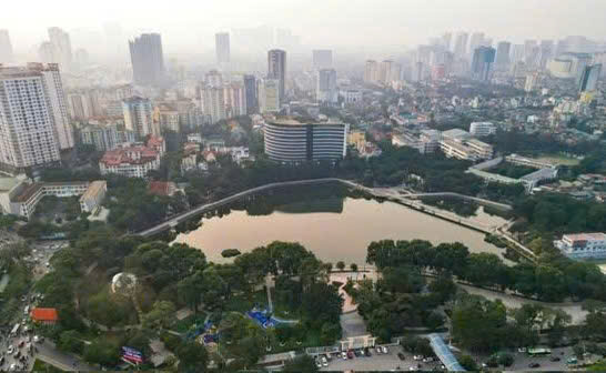 To&agrave;n cảnh một c&ocirc;ng vi&ecirc;n trung t&acirc;m H&agrave; Nội nh&igrave;n từ tr&ecirc;n cao, hồ nước v&agrave; mảng xanh c&acirc;y cối tạo n&ecirc;n &ldquo;l&aacute; phổi xanh&rdquo; giữa những t&ograve;a nh&agrave; cao tầng của đ&ocirc; thị.