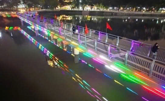 Hệ thống chiếu s&aacute;ng nghệ thuật ven hồ rực rỡ sắc m&agrave;u về đ&ecirc;m, phản chiếu xuống mặt nước, thu h&uacute;t người d&acirc;n dạo bộ v&agrave; chụp ảnh trong những ng&agrave;y đầu năm mới.