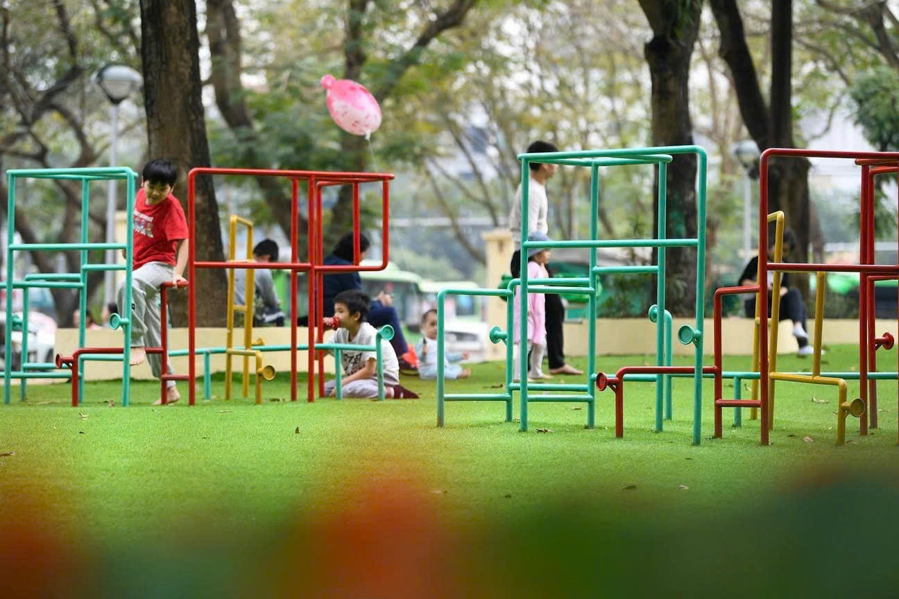 Trẻ em vui chơi tại khu vận động ngo&agrave;i trời trong c&ocirc;ng vi&ecirc;n, tận hưởng kh&ocirc;ng gian xanh m&aacute;t v&agrave; kh&ocirc;ng kh&iacute; trong l&agrave;nh dịp nghỉ Tết.