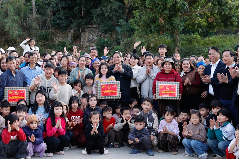 Thủ tướng tặng qu&agrave; c&aacute;c gia đ&igrave;nh trong khu t&aacute;i định cư - Ảnh: VGP/Nhật Bắc