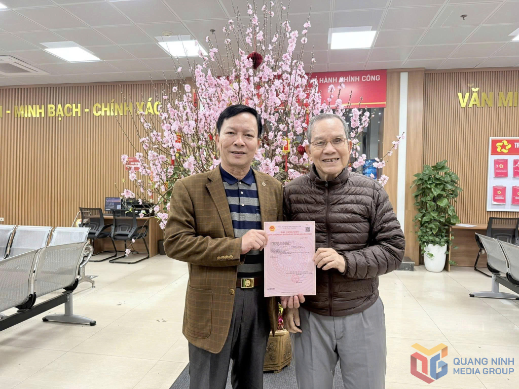 &Ocirc;ng Trần Th&ocirc;ng (b&ecirc;n phải) vui mừng khi được nhận &ldquo;sổ hồng&rdquo; của căn hộ t&aacute;i định cư tại chung cư sau nhiều năm chờ đợi