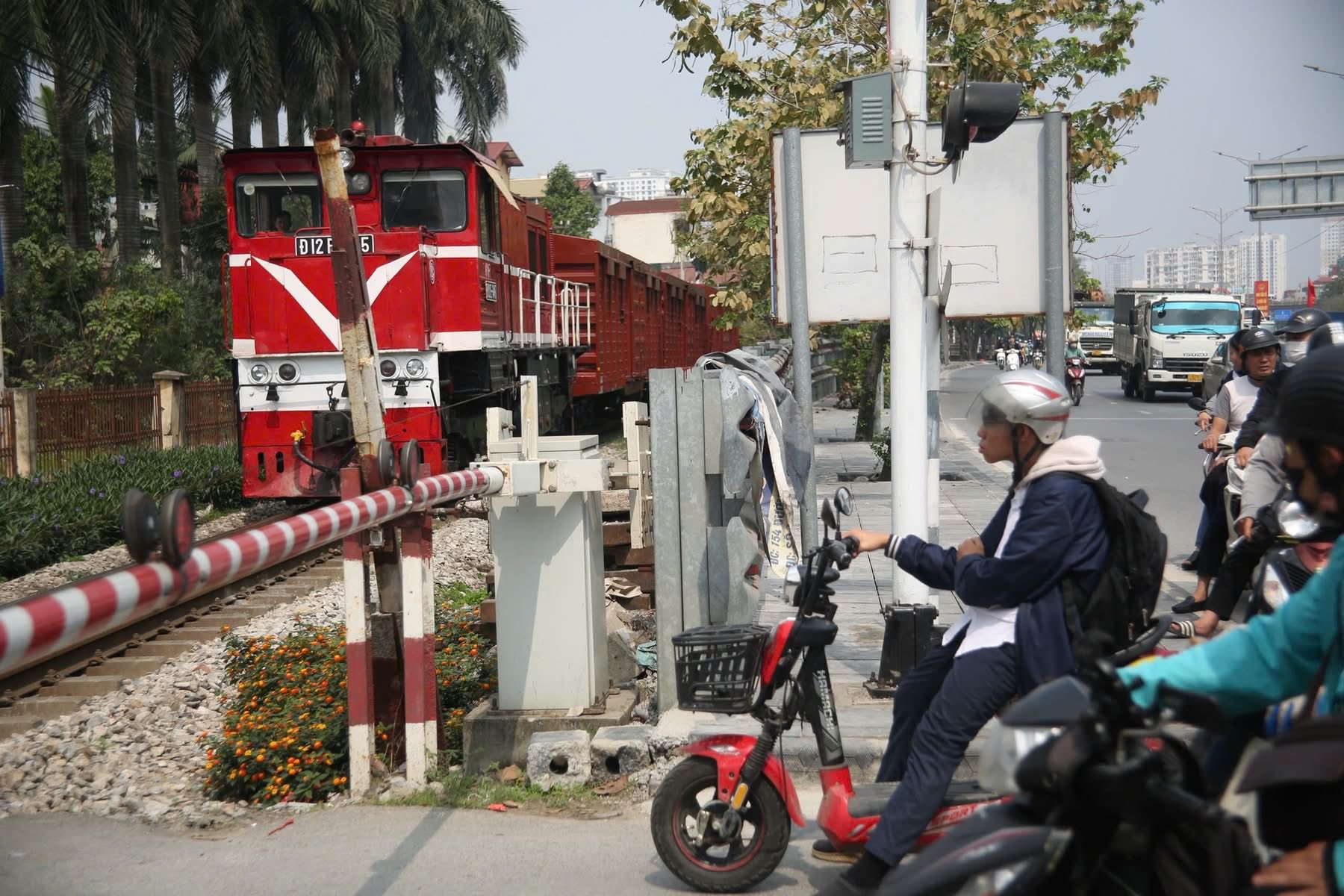 T&agrave;u hỏa lưu th&ocirc;ng qua đường ngang khi r&agrave;o chắn đ&atilde; hạ, người d&acirc;n dừng phương tiện chấp h&agrave;nh t&iacute;n hiệu an to&agrave;n tại điểm giao cắt đường sắt.