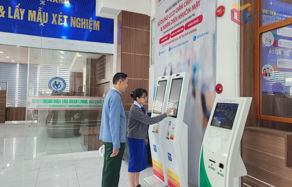 Nh&acirc;n vi&ecirc;n y tế Bệnh viện L&atilde;o khoa - Phục hồi chức năng Quảng Ninh hướng dẫn người d&acirc;n đăng k&yacute; kh&aacute;m bệnh qua ki-ốt th&ocirc;ng minh