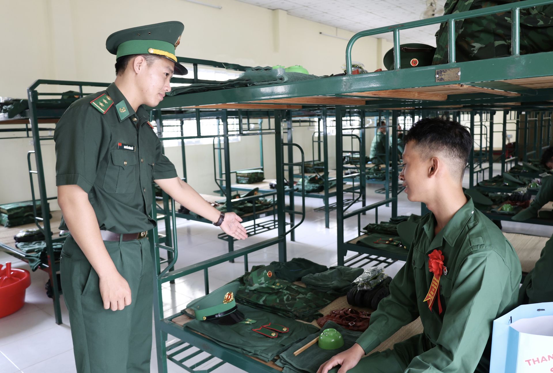 C&aacute;n bộ Trung đội giới thiệu với chiến sĩ mới về c&aacute;c qu&acirc;n tư trang. Ảnh: Tuấn Kiệt.