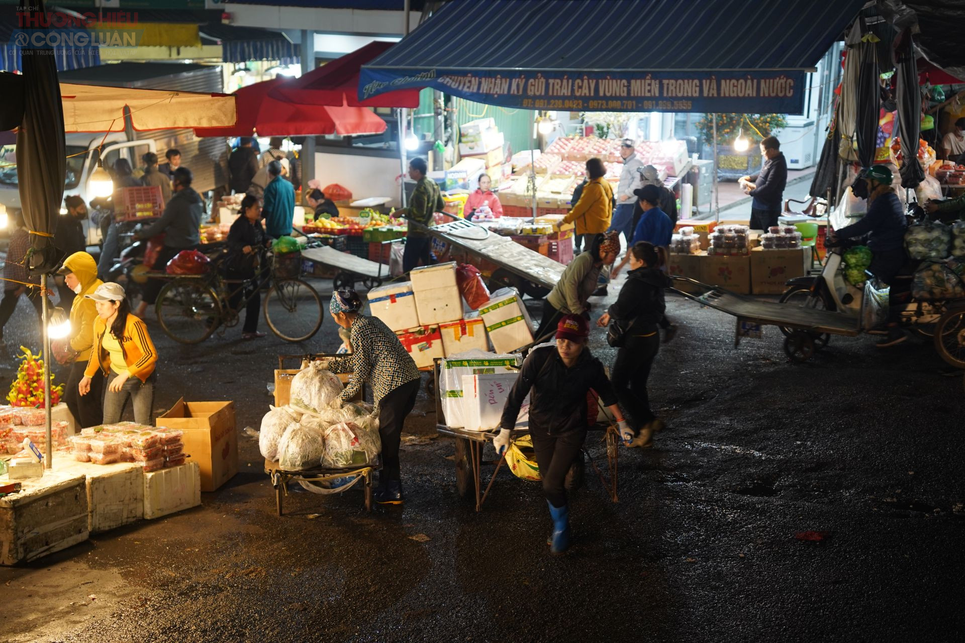 Giữa ánh đèn chợ đêm, cửu vạn miệt mài kéo từng chuyến hàng nặng trĩu. Giữa ánh đèn chợ đêm, cửu vạn miệt mài kéo từng chuyến hàng nặng trĩu.