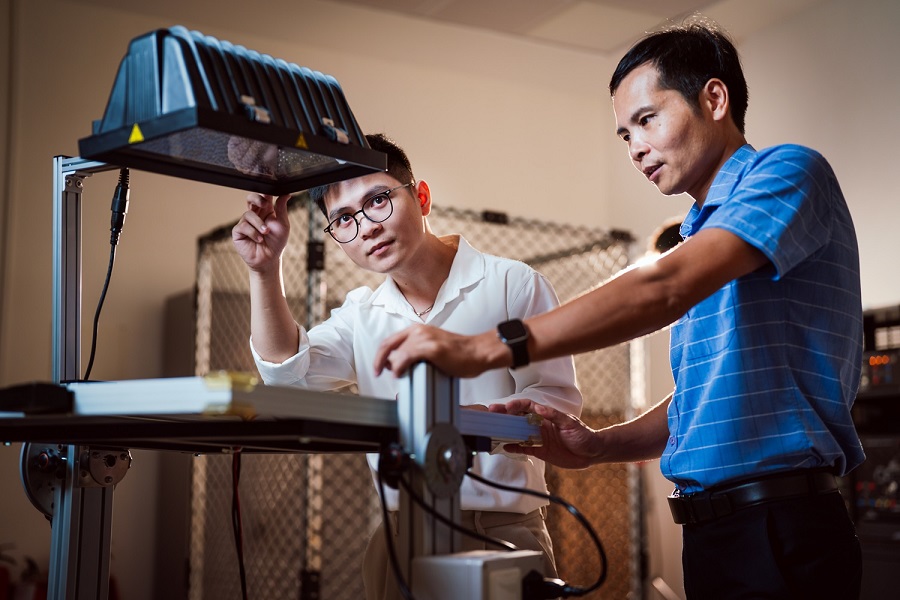 TS. Đỗ Danh Cường (&aacute;o xanh) - Trưởng nh&oacute;m nghi&ecirc;n cứu giới thiệu m&ocirc; h&igrave;nh th&iacute; nghiệm về năng lượng mặt trời