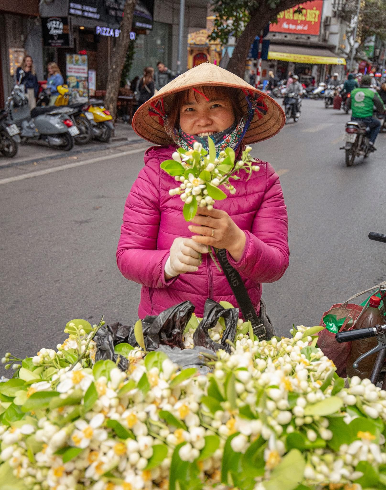 Người b&aacute;n hoa rong với g&aacute;nh hoa tươi tr&ecirc;n phố, g&oacute;p phần tạo n&ecirc;n n&eacute;t sinh động của đời sống đ&ocirc; thị H&agrave; Nội.