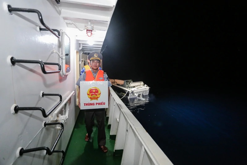 Tổ bầu cử đưa h&ograve;m phiếu v&agrave;o vị tr&iacute; tổ chức bầu cử tr&ecirc;n t&agrave;u kiểm ngư đang l&agrave;m nhiệm vụ tại v&ugrave;ng biển gi&aacute;p ranh Malaysia.