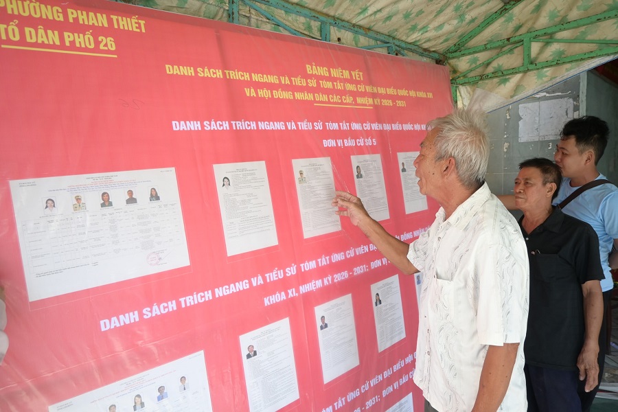 Ngư dân Võ Tiền (áo trắng) đang tìm hiểu tiểu sử, quá trình công tác của từng ứng cử viên Ngư dân Võ Tiền (áo trắng) đang tìm hiểu tiểu sử, quá trình công tác của từng ứng cử viên