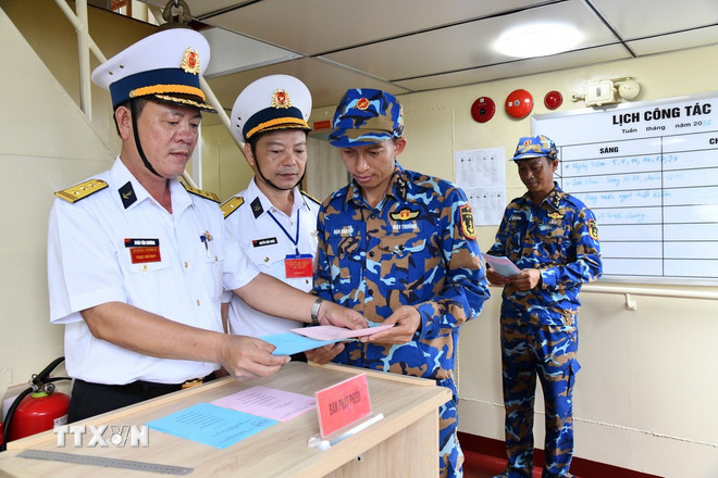 Cử tri tr&ecirc;n t&agrave;u hải qu&acirc;n nhận phiếu bầu cử. (Ảnh: TTXVN ph&aacute;t)