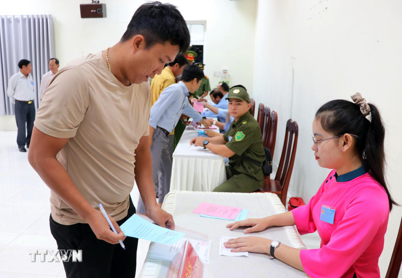 Th&agrave;nh vi&ecirc;n Tổ bầu cử số 6 (x&atilde; C&agrave; N&aacute;) ph&aacute;t phiếu bầu cho cư tri thực hiện quyền c&ocirc;ng d&acirc;n của m&igrave;nh. (Ảnh: C&ocirc;ng Thử/TTXVN)