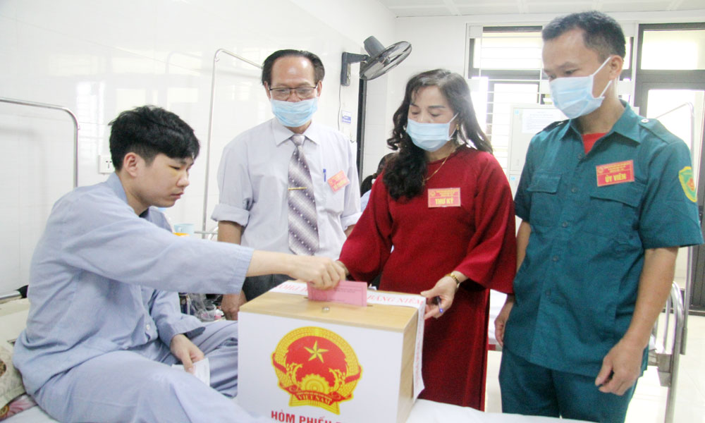 Th&agrave;nh vi&ecirc;n Tổ bầu cử Tổ d&acirc;n phố Ho&agrave;ng Văn Thụ, phường Bắc Giang mang h&ograve;m phiếu phụ để người bệnh đang điều trị nội tr&uacute; tại Bệnh viện Đa khoa Bắc Ninh số 1 thực hiện quyền c&ocirc;ng d&acirc;n.