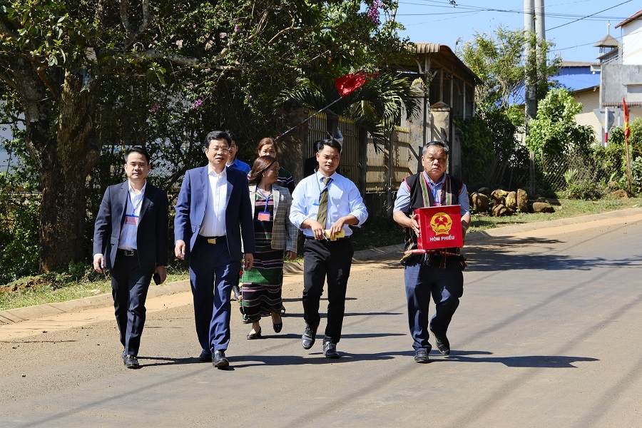 Đồng ch&iacute; Lưu Văn Trung, Ph&oacute; B&iacute; thư Tỉnh ủy, Chủ tịch HĐND tỉnh, Chủ tịch Ủy ban Bầu cử tỉnh L&acirc;m Đồng c&ugrave;ng c&aacute;n bộ x&atilde; Đức An mang th&ugrave;ng phiếu di động đến nh&agrave; cử tri