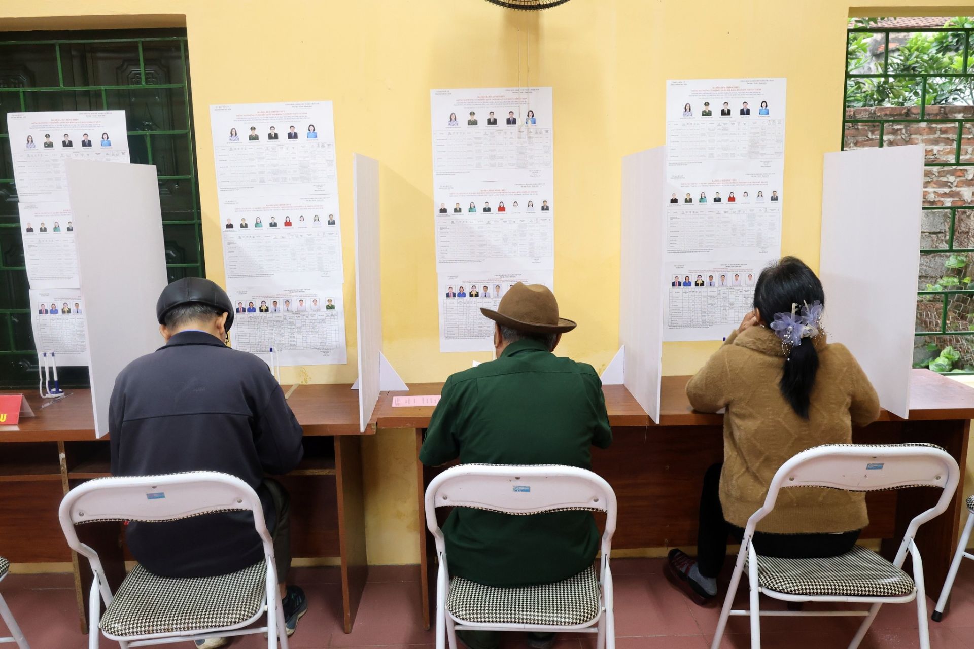 Cử tri nghi&ecirc;n cứu danh s&aacute;ch ứng cử vi&ecirc;n trước khi thực hiện quyền bầu cử tại khu vực bỏ phiếu.
