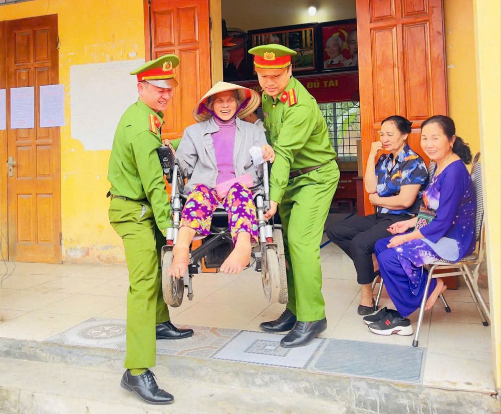C&aacute;n bộ c&ocirc;ng an x&atilde; Lục Nam hỗ trợ người yếu thế đi bầu cử.