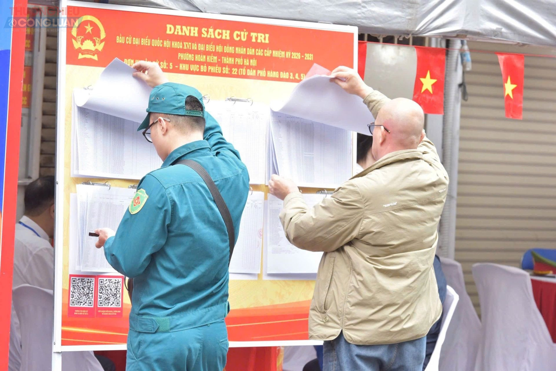 Cử tri tra cứu th&ocirc;ng tin tr&ecirc;n bảng ni&ecirc;m yết danh s&aacute;ch cử tri tại khu vực bỏ phiếu trước khi thực hiện quyền bầu cử. Ảnh: Hương Giang