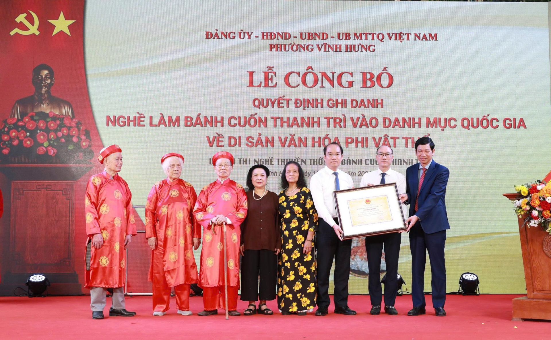 L&atilde;nh đạo v&agrave; đại diện l&agrave;ng nghề đ&oacute;n nhận Quyết định ghi danh &ldquo;Nghề l&agrave;m b&aacute;nh cuốn Thanh Tr&igrave;&rdquo; v&agrave;o Danh mục Di sản văn h&oacute;a phi vật thể quốc gia tại phường Vĩnh Hưng.