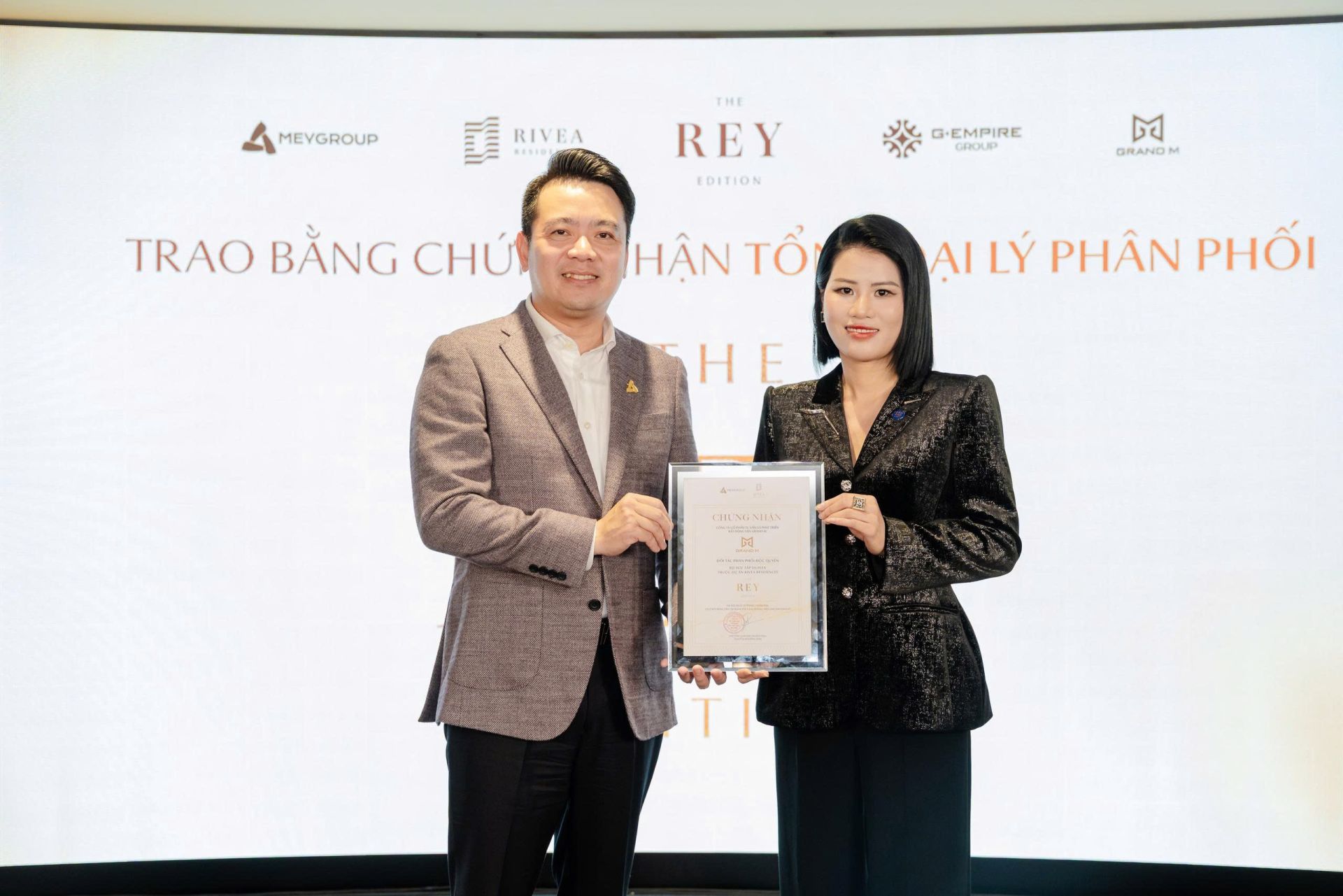 Đại diện chủ đầu tư trao bằng chứng nhận Tổng Đại l&yacute; ph&acirc;n phối. Ảnh: Grand M